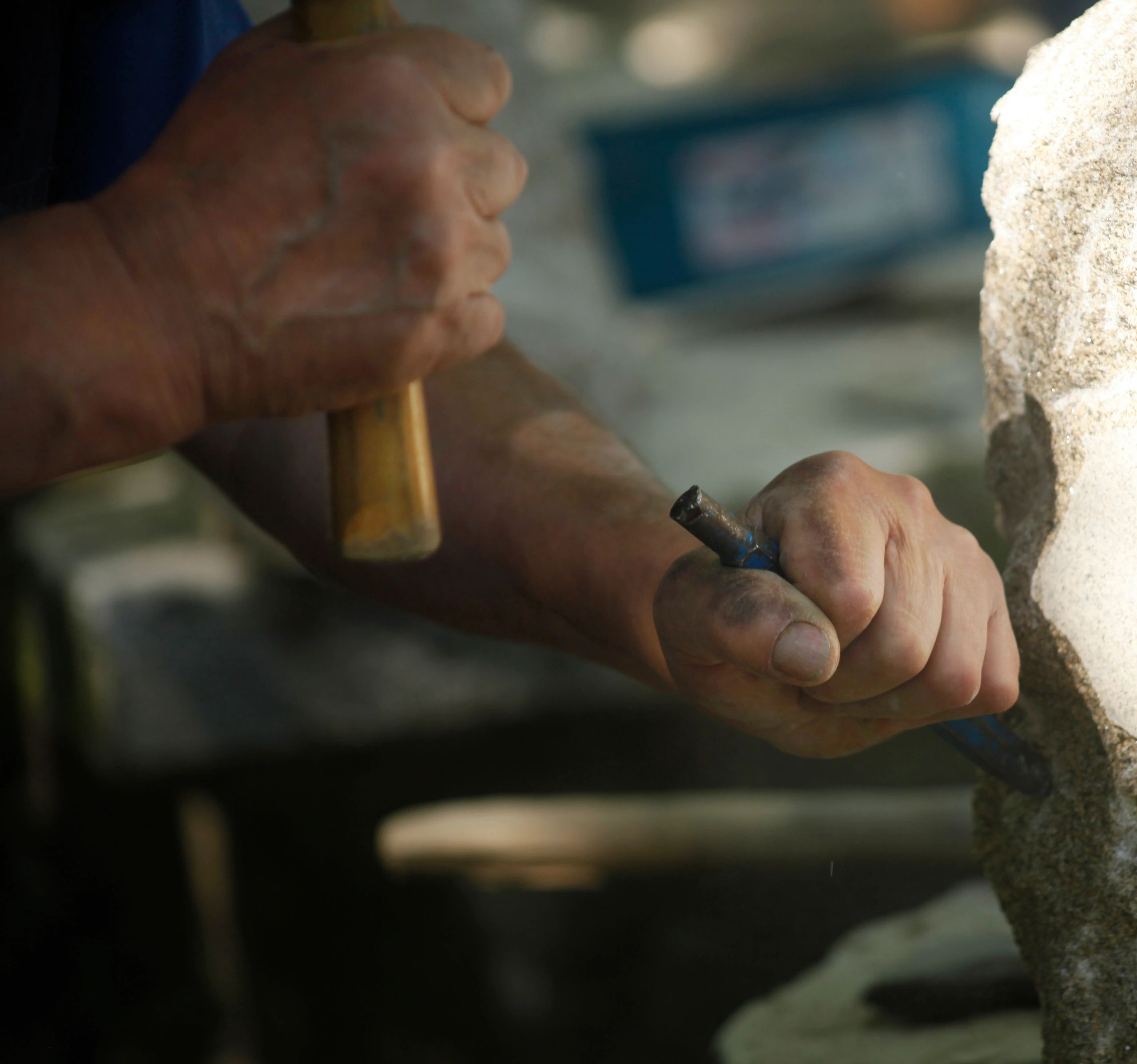 Hands carving stone with a chisel
